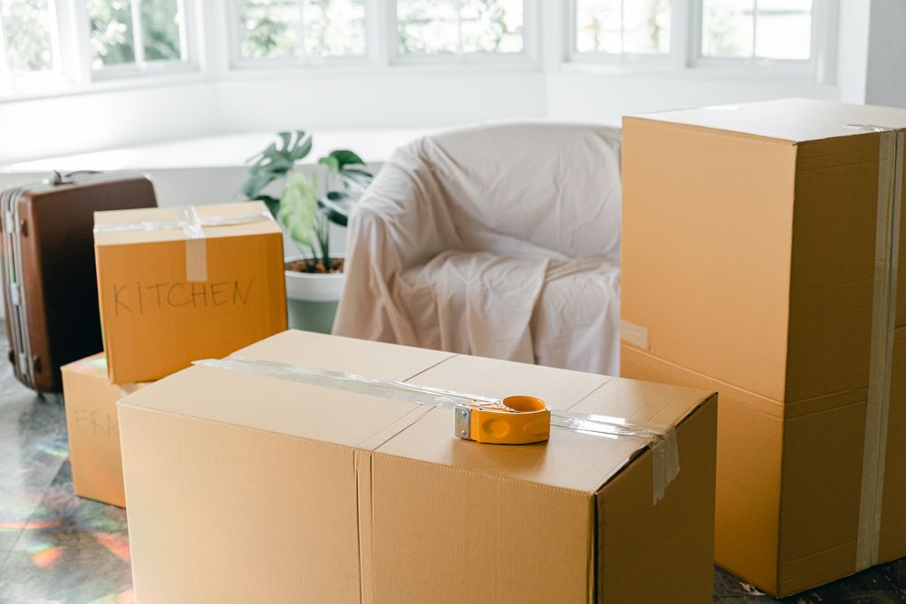 Packed cardboard moving boxes in an emptied living room
